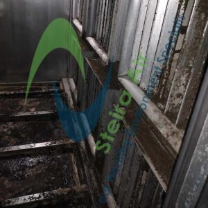 HVAC coil before steam cleaning, showing dirt, grease, and grime buildup on metal surfaces, with Steira Air logo visible, emphasizing the need for eco-friendly cleaning solutions.